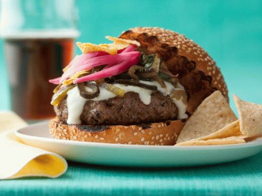 Fotografie cheeseburgeru se sýrovou omáčkou a zelenými chilli papričkami